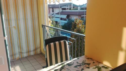 einen Stuhl auf einem Balkon mit Stadtblick in der Unterkunft Appartamento alle Magnolie in Sirmione