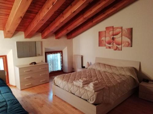 1 dormitorio con 1 cama en una habitación con techos de madera en La casetta di Chiara en Fumane