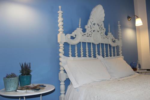 a bedroom with a white bed with a blue wall at Segredo d'Alecrim in Fronteira