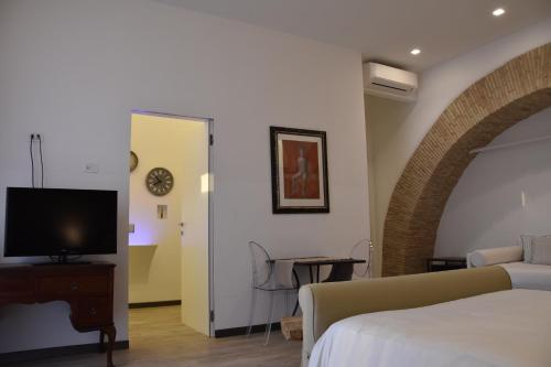 - une chambre avec un lit et une télévision dans l'établissement La Casa nel Borgo Antico, à Melfi