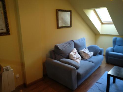 a blue couch in a living room with a window at Apartamento Rural Felechosa in Felechosa