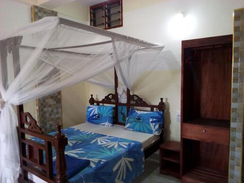 a bedroom with a bed with a canopy at Premier Guest Residence Hotel in Malindi