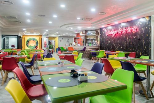 a restaurant with tables and colorful chairs in a room at ibis Styles Roma Vintage in Rome