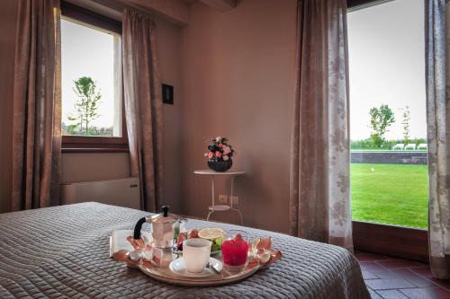 a tray of food and drinks on a bed with a window at Belvivere Suites in Sona