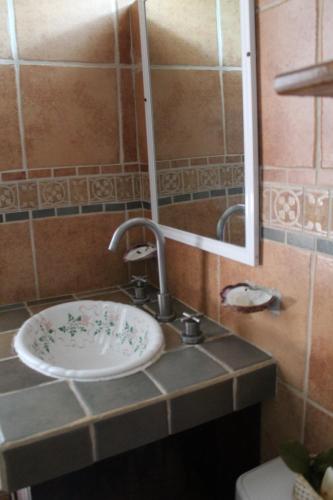 Hotel Mayto في Ipala: حمام مع حوض ومرآة