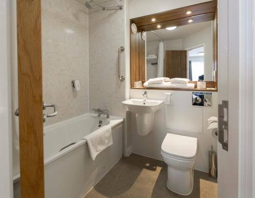 a bathroom with a sink and a toilet and a bath tub at Starling Cloud in Aberystwyth