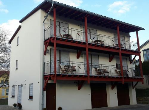 - un bâtiment blanc avec des balcons rouges dans l'établissement Gästehaus Bräuscheuere, à Homburg