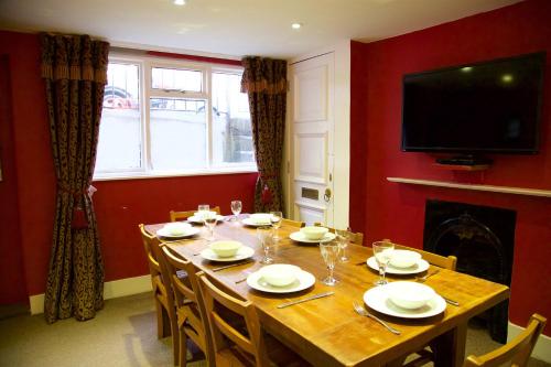 a dining room with a table with chairs and a television at The Artist House in Brighton & Hove