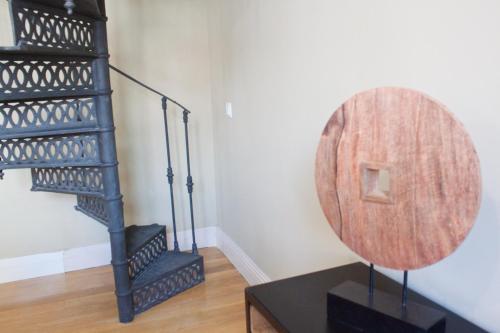 a black spiral staircase in a room with a wooden table at Vut carretas 21 in Madrid