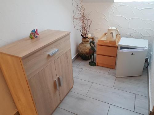 a kitchen with a wooden cabinet and a refrigerator at Villa Maximilian in Srokowo