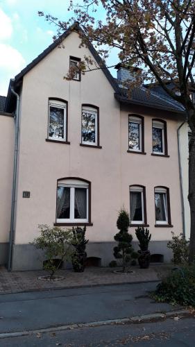 a white house with black windows on a street at Ferienwohnung Gladbeck-Rohde in Gladbeck