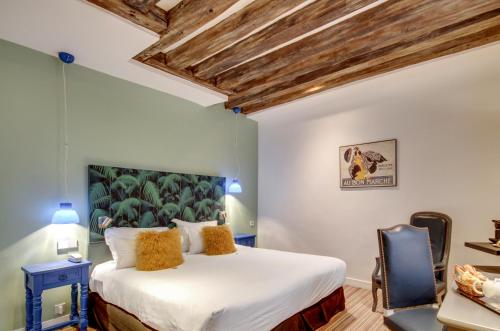 a bedroom with a large bed and a chair at Hôtel Sèvres Saint Germain in Paris
