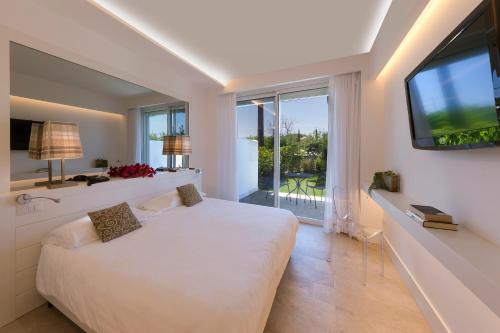 a bedroom with a white bed and a large window at Hotel Alpha in Sant'Agnello