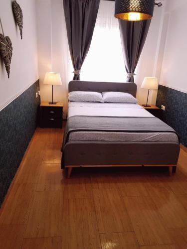 a bedroom with a bed with two lamps and a window at Apto Valentina Salou in Salou