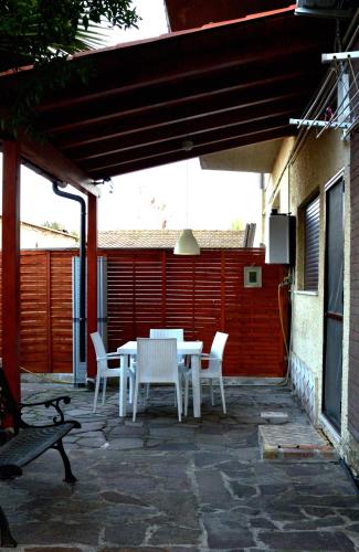 a patio with a white table and white chairs at Casa di Alberta in Rome