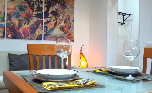a dining table with two glasses and plates on it at Casa di Alberta in Rome