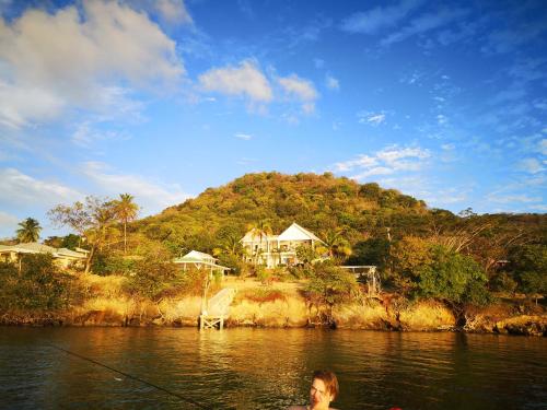 a man in the water with a fishing pole in the water at Green Roof Inn in Carriacou