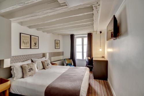 Una habitación de hotel con una cama y un televisor. en Hôtel Sèvres Saint Germain, en París