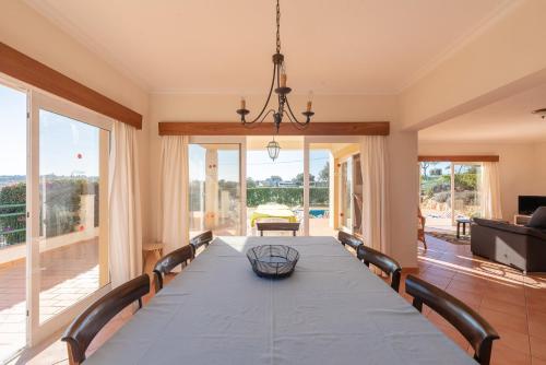 a dining room with a long table and chairs at Villa Agua by Gabi Miguel in Albufeira
