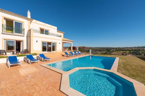 a villa with a swimming pool in front of a house at Villa Agua by Gabi Miguel in Albufeira
