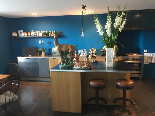 une cuisine avec un îlot doté d'un vase d'animaux. dans l'établissement Côté Jardin, Chambres d’hôtes B&B, à Le Pont-de-Beauvoisin