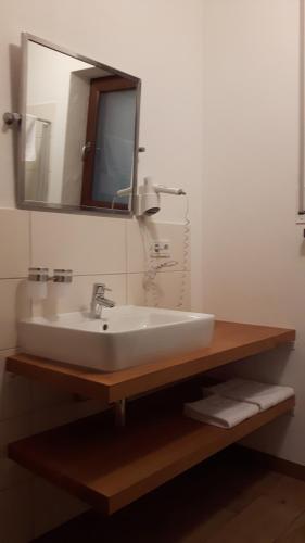 bagno con lavandino bianco e specchio di Gästehaus Bräuscheuere a Homburg