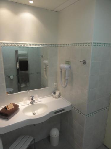 a bathroom with a sink and a mirror at Hôtel Au Logis des Remparts in Saint-Émilion