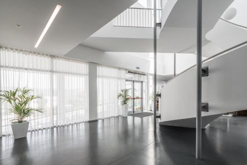 an office lobby with a staircase and plants at Boticas Hotel Art & SPA in Boticas