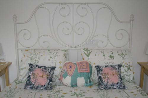 a white bed with two pillows and an elephant on it at Fantastic, 100 meters from the beach in Can Picafort