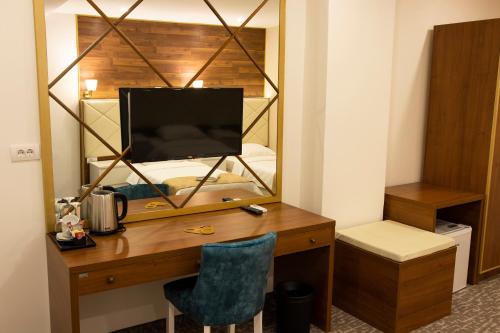 a desk with a television and a mirror in a room at Luxury Rooms Skadarlija in Belgrade