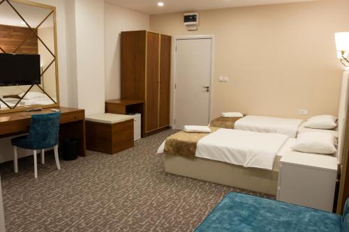 a hotel room with two beds and a desk and a computer at Luxury Rooms Skadarlija in Belgrade