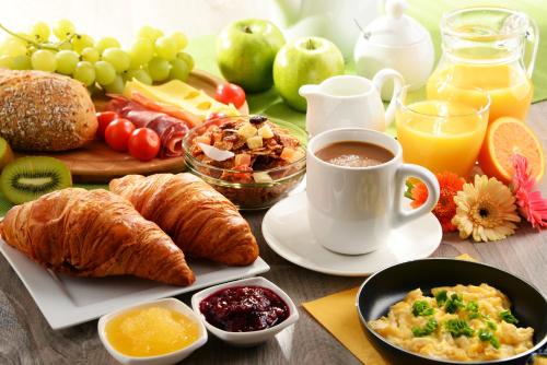 a table topped with breakfast foods and a cup of coffee at Schlosshotel Braunfels & Himmelreich in Braunfels