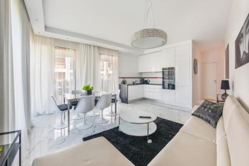 ein Wohnzimmer mit einer weißen Couch und einem Tisch in der Unterkunft Luxury Long Island Suite in Danzig