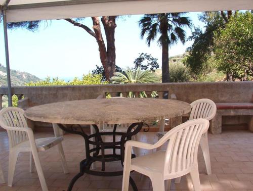 einen Tisch und Stühle auf einer Terrasse in der Unterkunft Villa Caferì in San Giorgio