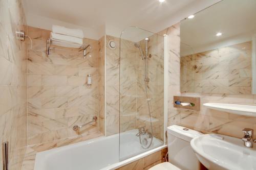 a bathroom with a shower and a tub and a sink at Hôtel Sèvres Saint Germain in Paris