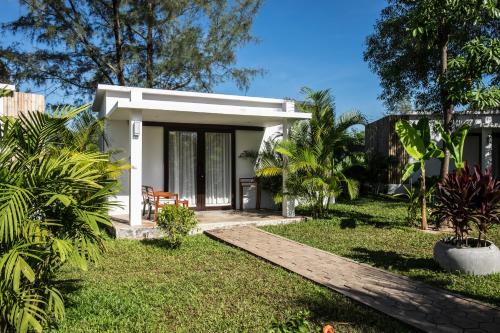 a small white house with a garden at Sahaa Beach Resort in Sihanoukville