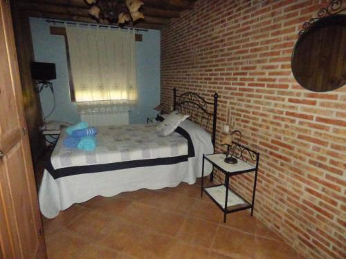NavasfríasにあるUn Rincón Salmantinoのレンガの壁、ベッド付きのベッドルーム1室