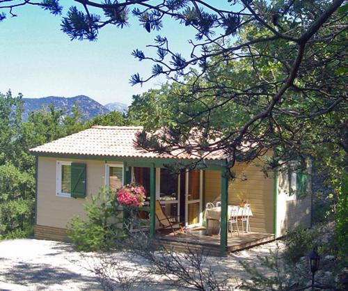 a small house with a porch and a patio at La Drugère - Gîtes et Roulottes in Nyons