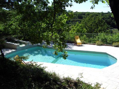 a swimming pool with a chair in a yard at La Drugère - Gîtes et Roulottes in Nyons