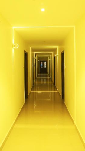 an empty hallway with yellow walls and a long corridor at HOTEL KEK GRAND PARK in Chennai