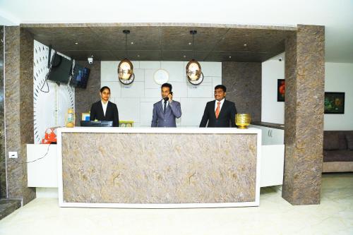 three men in suits standing behind a counter at HOTEL KEK GRAND PARK in Chennai