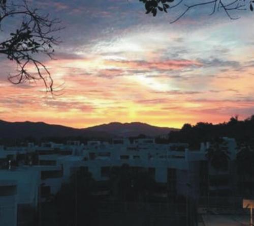 a view of a city with a sunset in the background at Villa Vassallo in Ponce