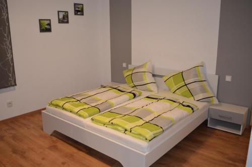 - un lit avec des draps et des oreillers jaunes et blancs dans l'établissement 34a Paulstraße, à Postbauer-Heng
