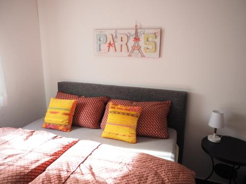 - une chambre dotée d'un lit avec des oreillers colorés dans l'établissement 2-Zimmer-Whg im Souterrain mit neuer Sauna, à Großenseebach