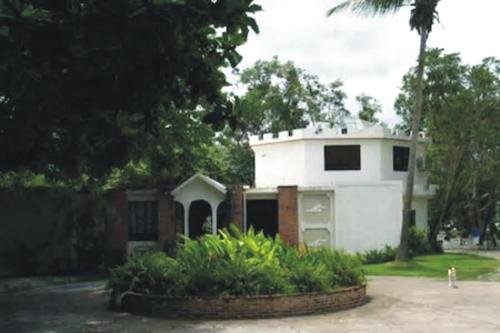 a white house with a lot of plants at Villa Vassallo in Ponce