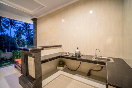 uma casa de banho com um lavatório e uma grande janela em Pondok Putri Sari em Ubud