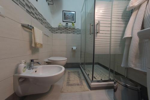 a bathroom with a toilet and a sink and a shower at La maison de Julie in Vico Equense