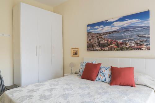 1 dormitorio con 1 cama con almohadas rojas y azules en La maison de Julie en Vico Equense