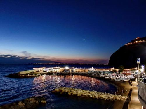 a pier with chairs and the ocean at night at Hotel Giosue' a mare Sorrento in Meta