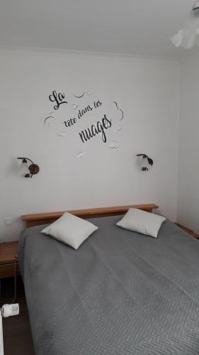 a bedroom with a bed with a sign on the wall at Gite du village in Estréboeuf